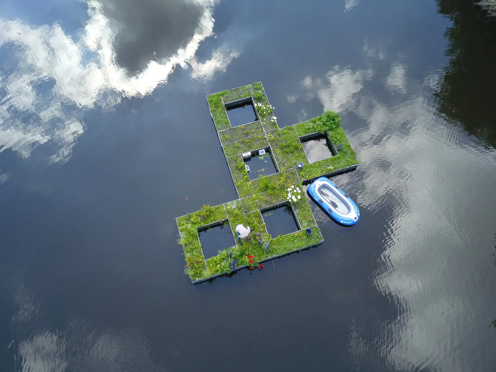 Luchtfoto van het Aqua Blocks-eiland in Eindhoven, met meetapparatuur en een onderhoudsmedewerker